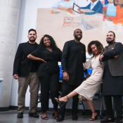 Excerpt of a larger group shot showing a group of people in front of the new mural