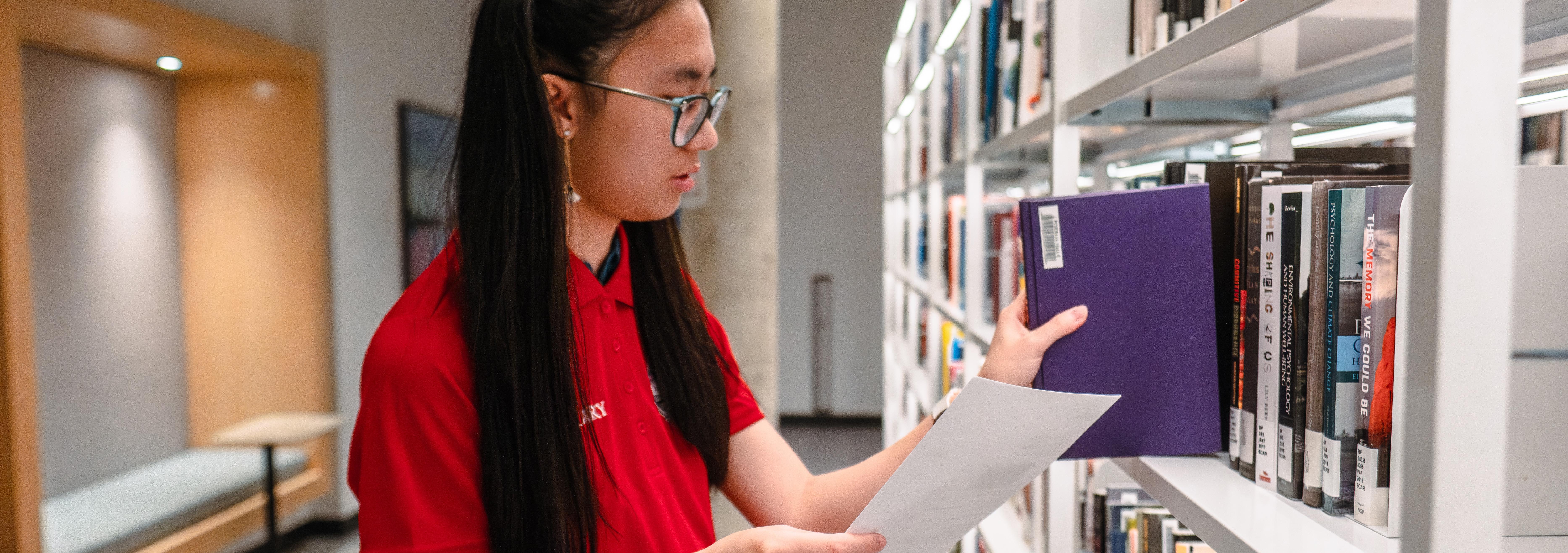 A student at a bookshelf