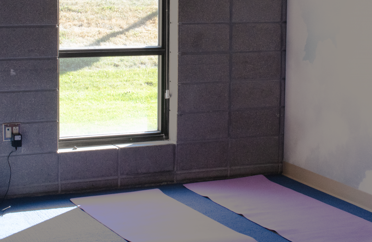 A room with a cloud mural and yoga mats laid on top of a mat. 