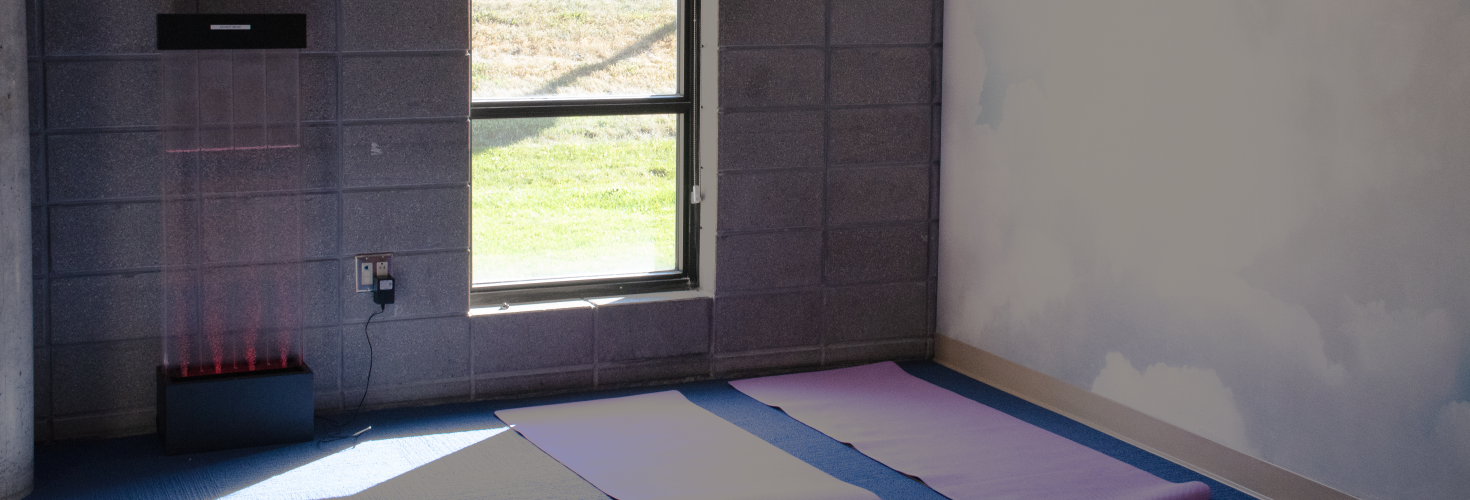 A room with a cloud mural and yoga mats laid on top of a mat.