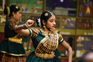 A dancer from Shilompoli Shethra Dance Academy, raises her hand in a transitional Tamil dance.
